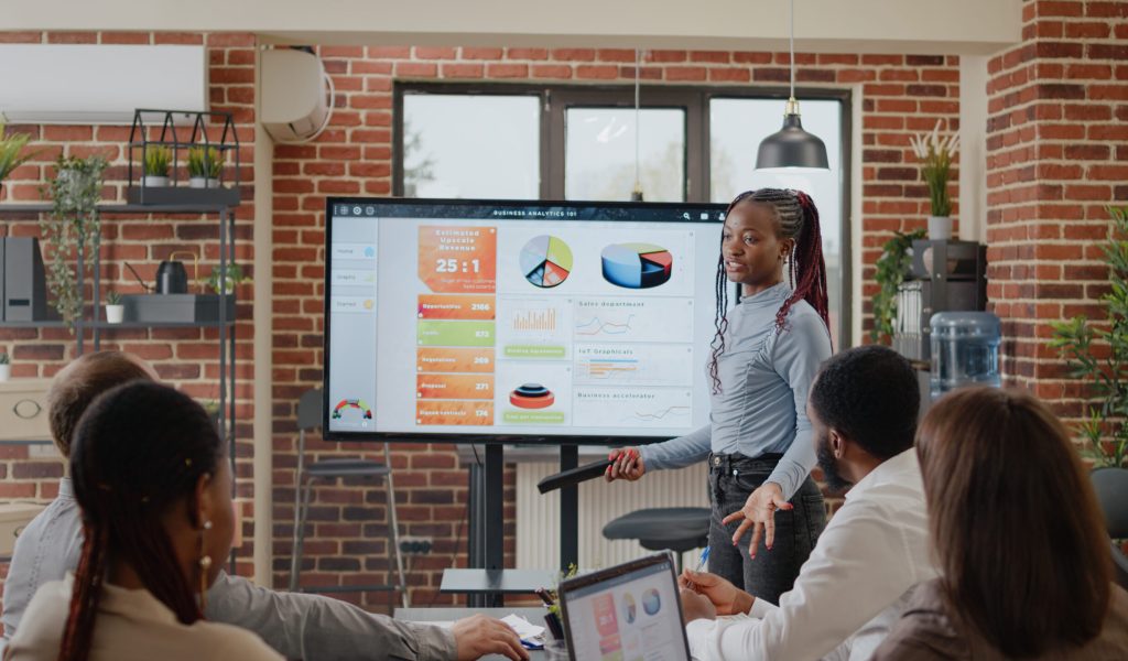 Close up of woman doing business presentation in boardroom, explaining charts analysis to workmates for comany development and growth. Employee presenting marketing strategy on screen.