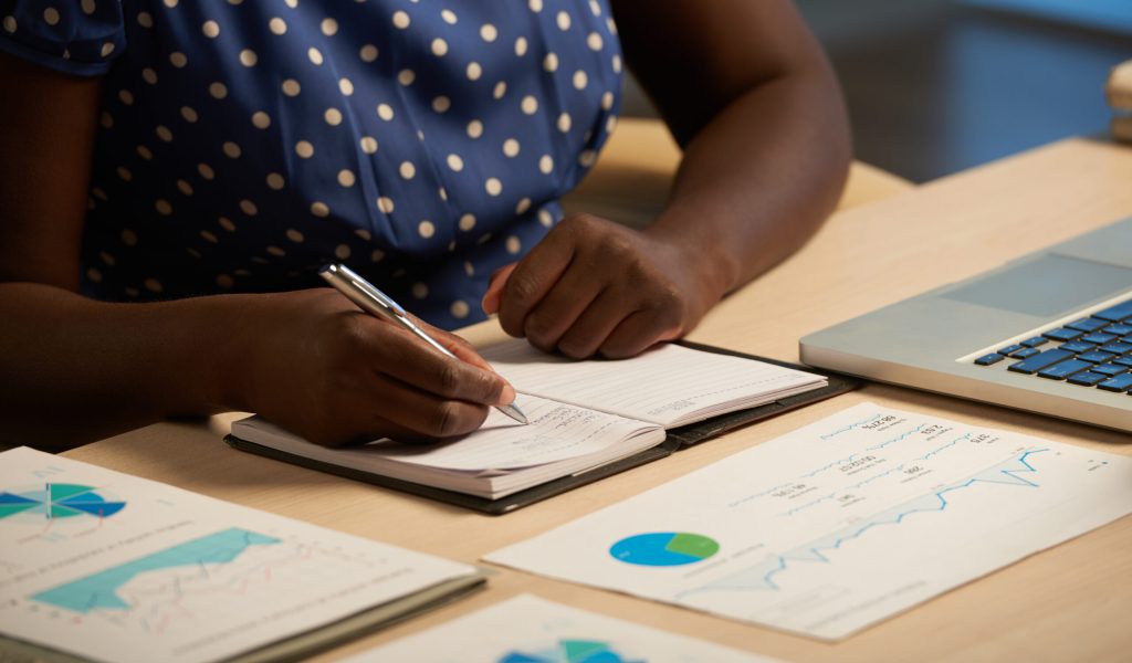 Cropped image of business lady taking notes in her planner